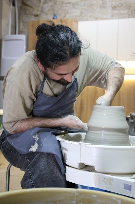 Potter shaping wet clay on a wheel inside a Matera ceramics workshop