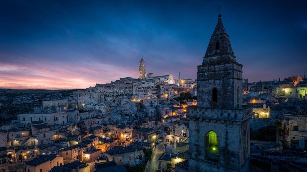 Nächtliche Skyline von Matera mit leuchtenden Gassen und Kirchturm