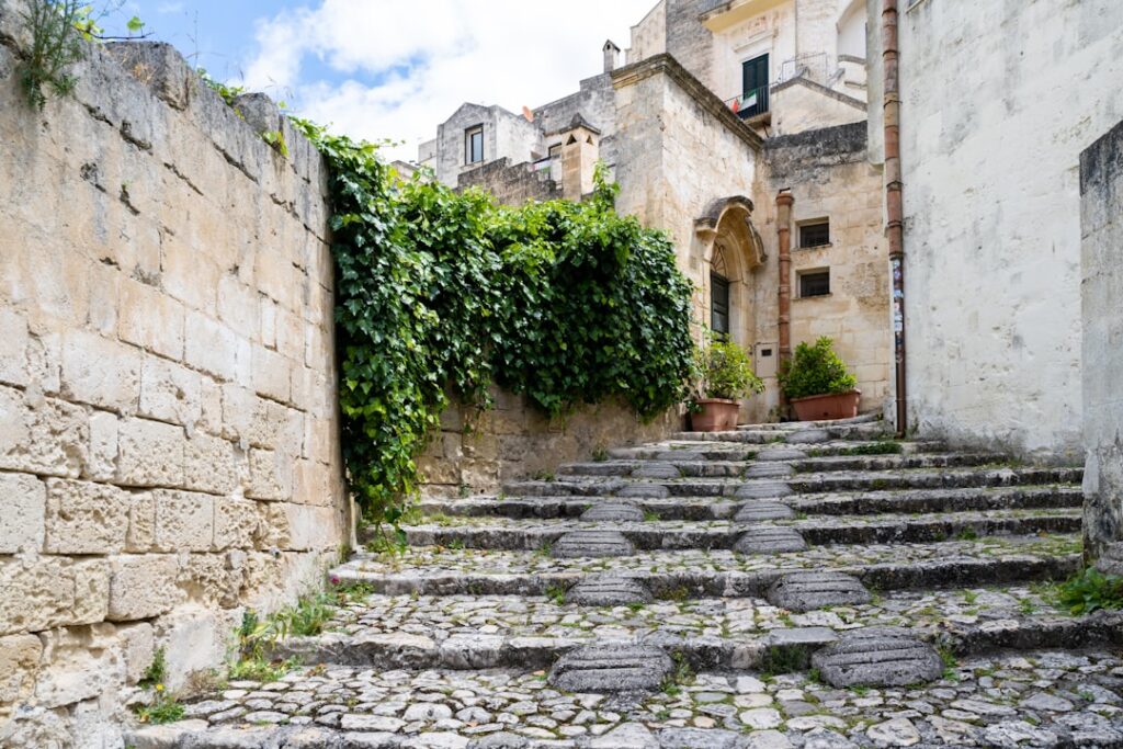 alte Mauerstufen mit Efeu und historischen Häusern in Matera