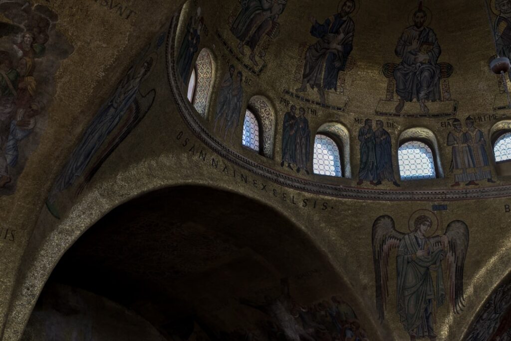 Gilded interior mosaics and arched windows inside St. Mark's, Venice