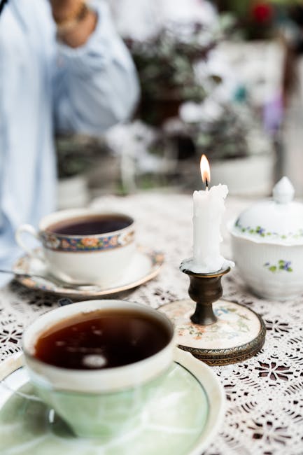 Deux tasses de thé et bougie allumée sur nappe en dentelle à Padoue