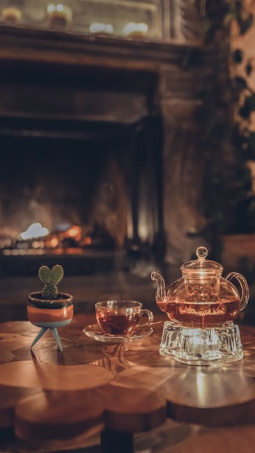 Théière en verre et tasse devant une cheminée crépitante, ambiance Padoue