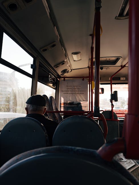Binnenin bus zit passagier met pet die vooruit kijkt in Padua