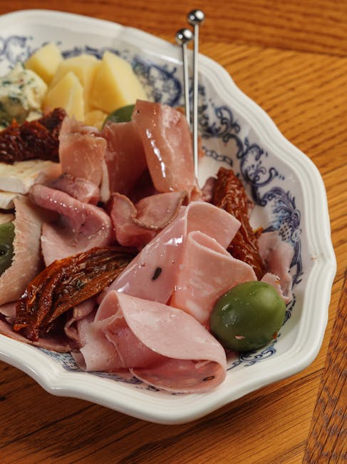 Talerz cicchetti w Padwie z mortadelą, suszonymi pomidorami i oliwką.