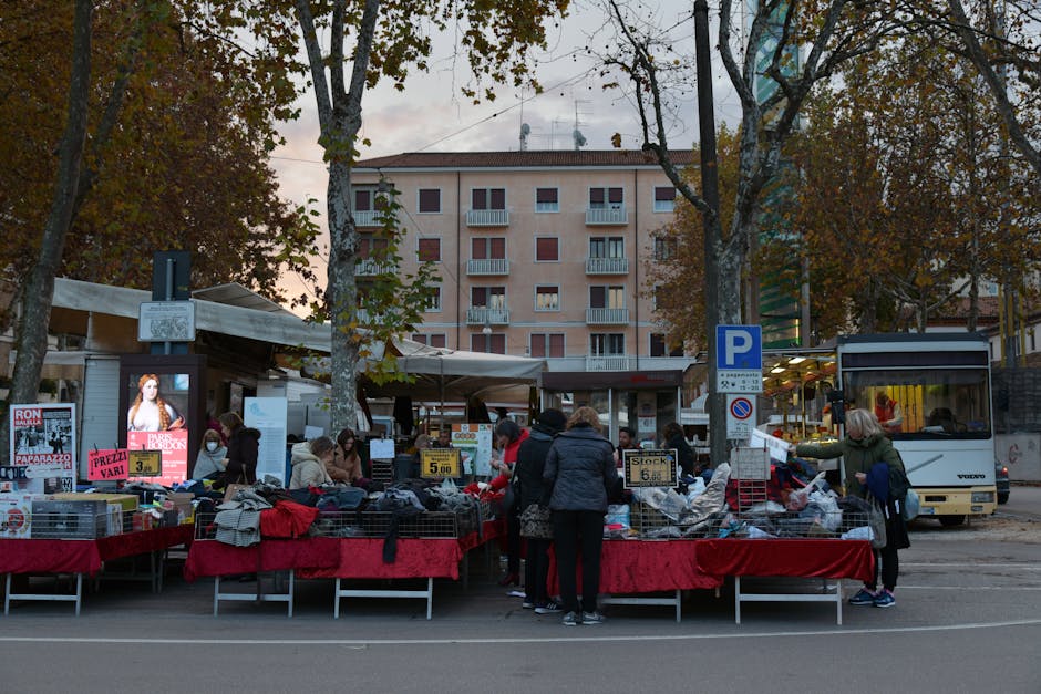 Marktkramen en marktbezoekers op plein, bus stopt naast kraampjes in Padua