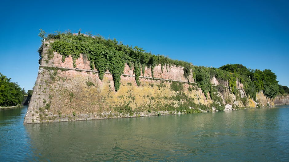 Ivy-covered fortified wall rising from the water on Lake Garda