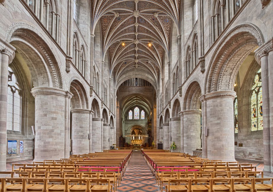 Langes gotisches Kirchenschiff mit gewölbter Decke und Holzstühlen