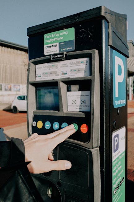Parcometro con mano che preme il pulsante per pagare parcheggio a Padova