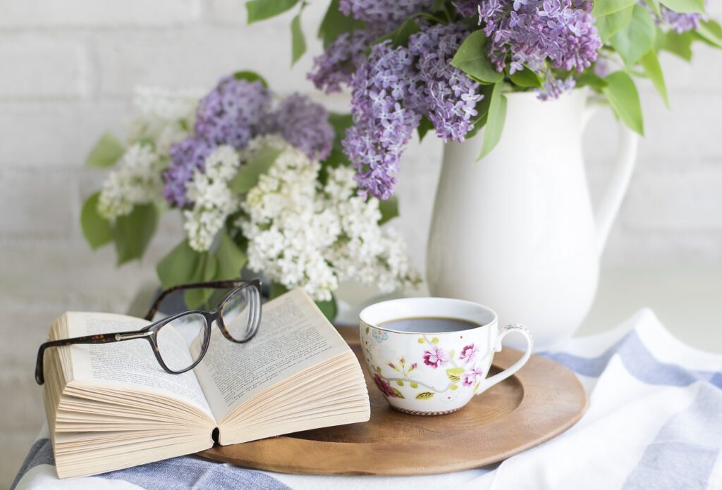 Tasse fleurie, livre ouvert et lilas en vase sur plateau, à Padoue