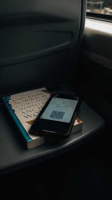 Smartphone affichant un QR ticket posé sur un livre dans un train