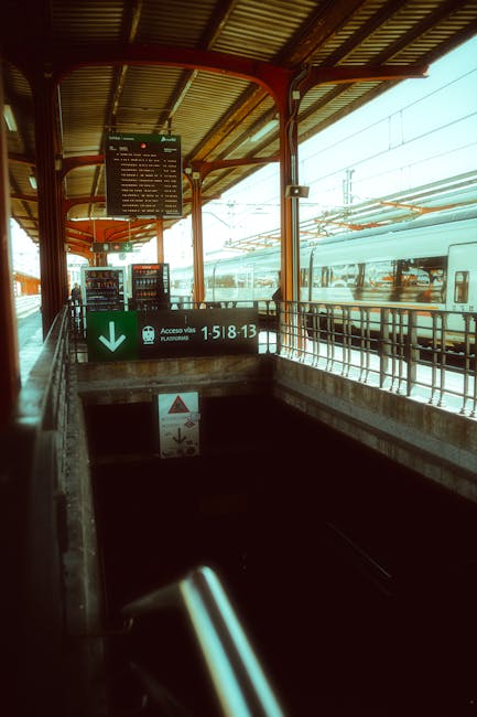 Banchina della stazione con treno e scale verso sottopassaggio a Padova