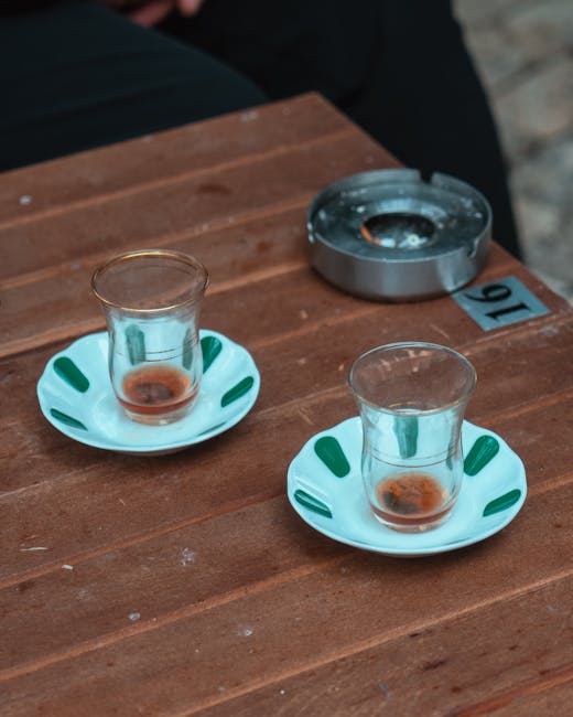 Deux verres à thé vides sur table en bois, cendrier présent à Padoue