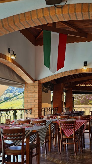 Taras restauracji z włoską flagą i kratowanymi obrusami w Arquà Petrarca