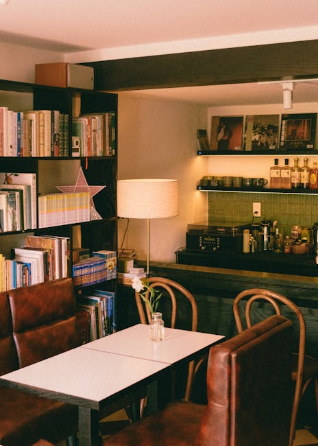 Cozy leather seating and bookshelves beside a lamp in a cafe.