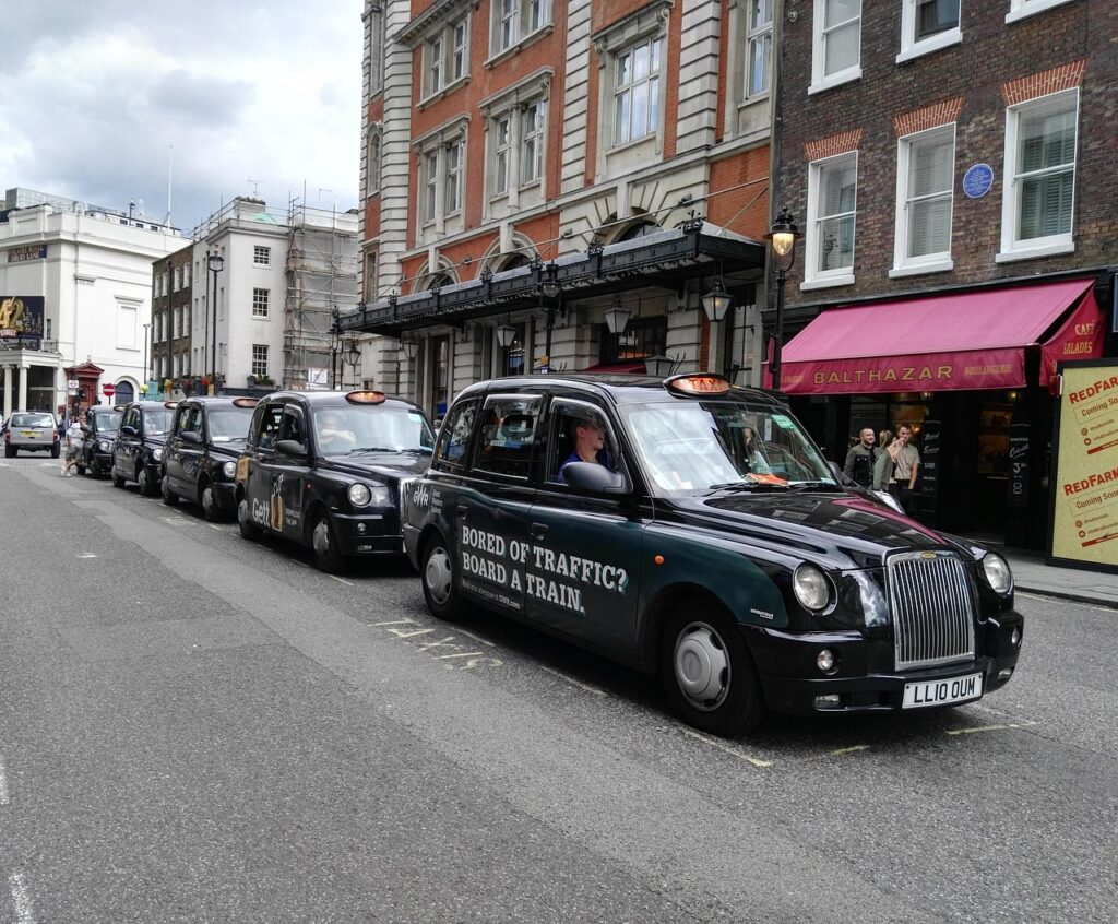 Fila di taxi neri parcheggiati davanti a edifici cittadini