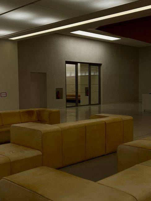 Salle d'accueil moderne avec banquettes jaunes dans un musée de Padoue