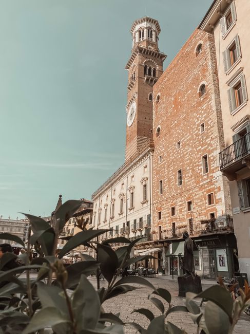 Klassieke kloktoren en bakstenen gevels op een plein in Padua