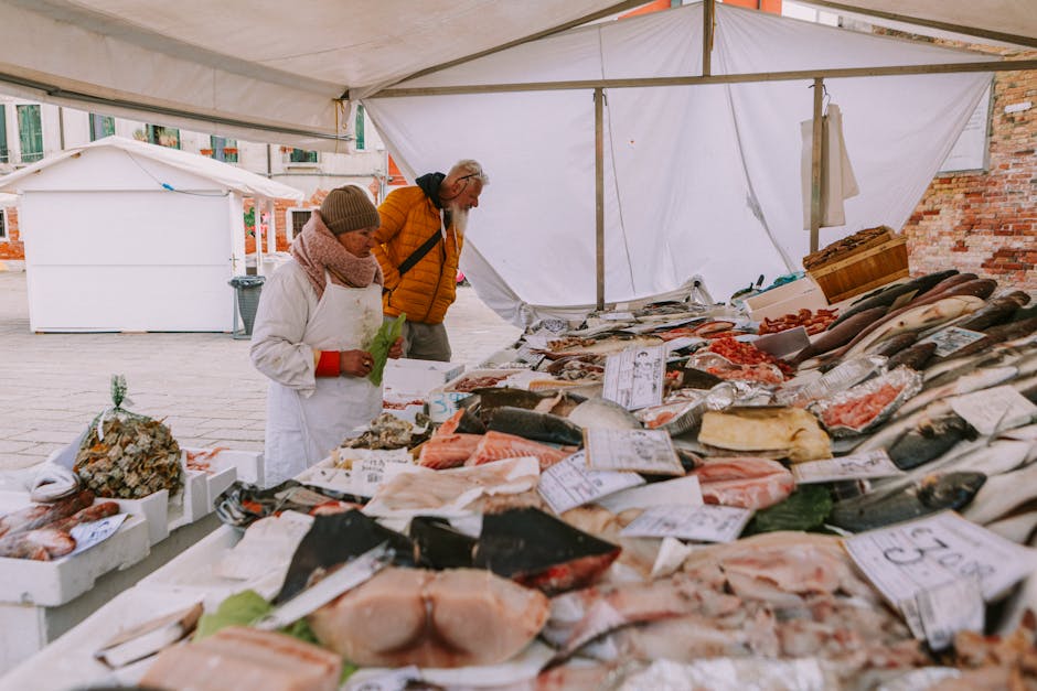 Stoisko z rybami na targu w mieście Chioggia, sprzedawczyni układa ryby