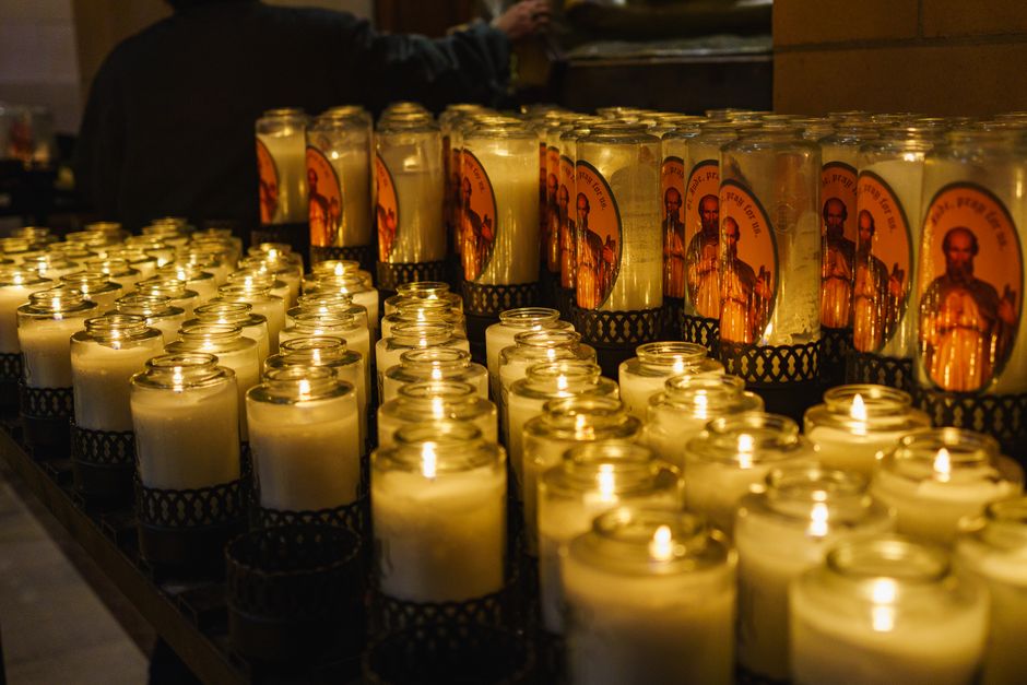 Rij brandende kaarsen in glazen bekers binnen de basiliek van Padua