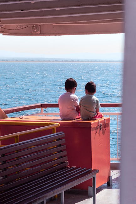 Deux enfants assis sur le ferry regardant le Lac de Garde