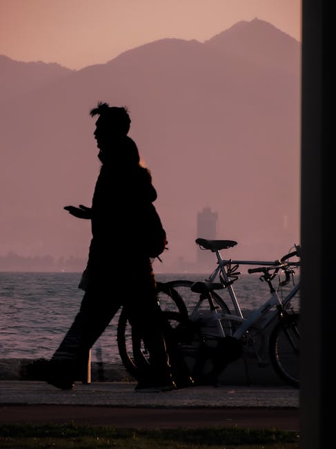 Silhouette d'une personne près d'un vélo au bord du Lac de Garde