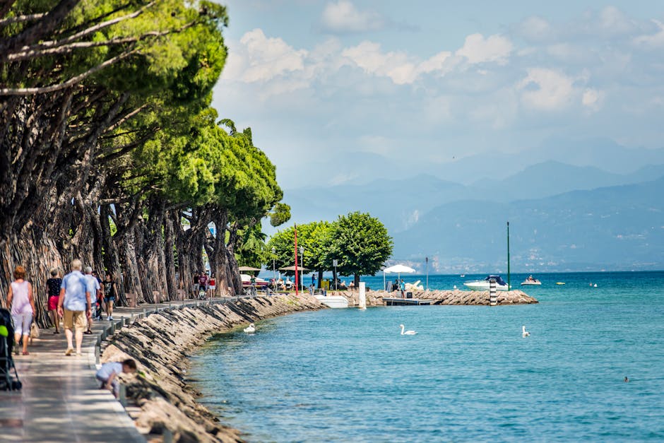 Promenade bordant le Lac de Garde avec cygnes, arbres et passants