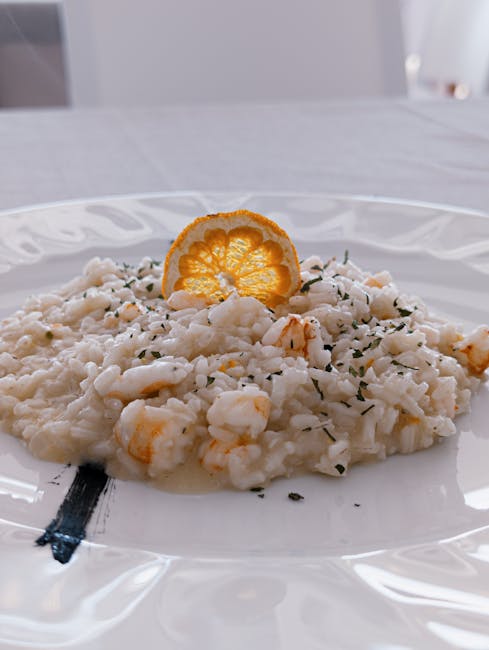 Risotto ai gamberi guarnito con fetta d'arancia, cucina del Lago di Garda