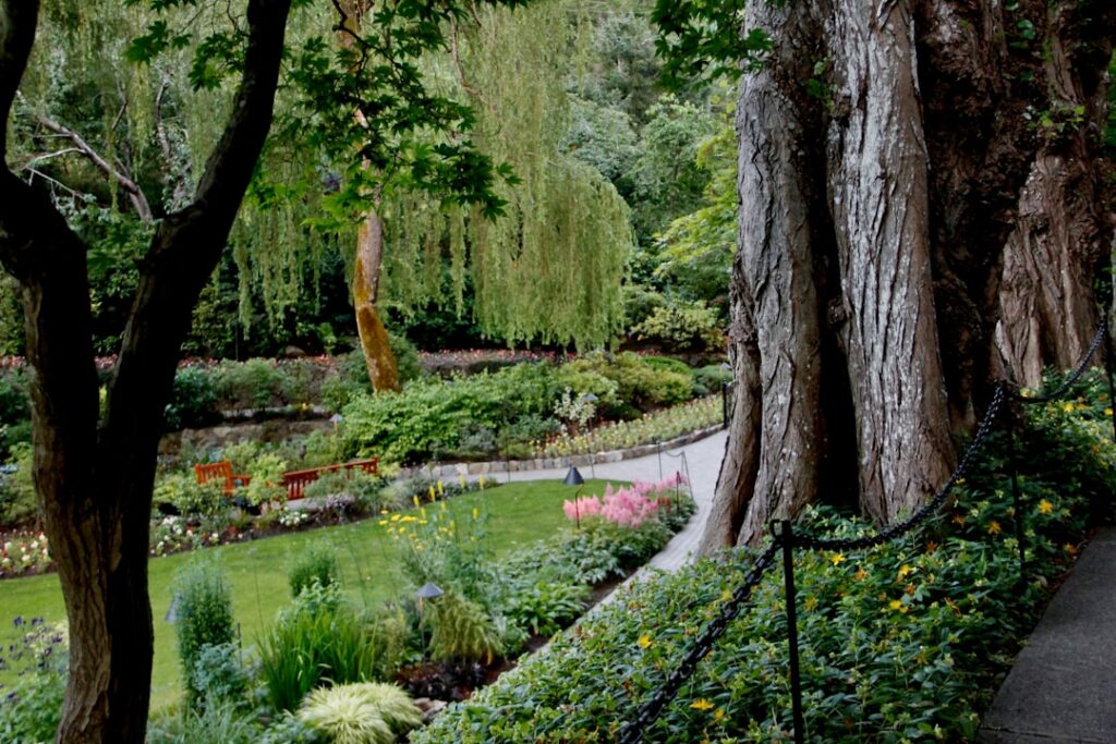Jardin ombragé avec bancs et massifs fleuris dans parc du Lac de Garde