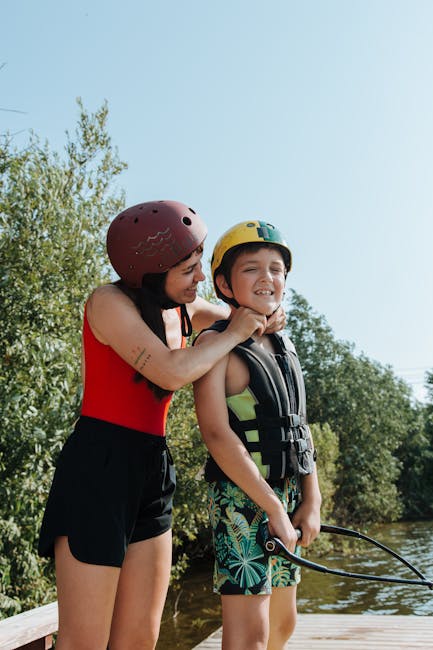 Adulte ajustant le casque d'un garçon en gilet près du Lac de Garde