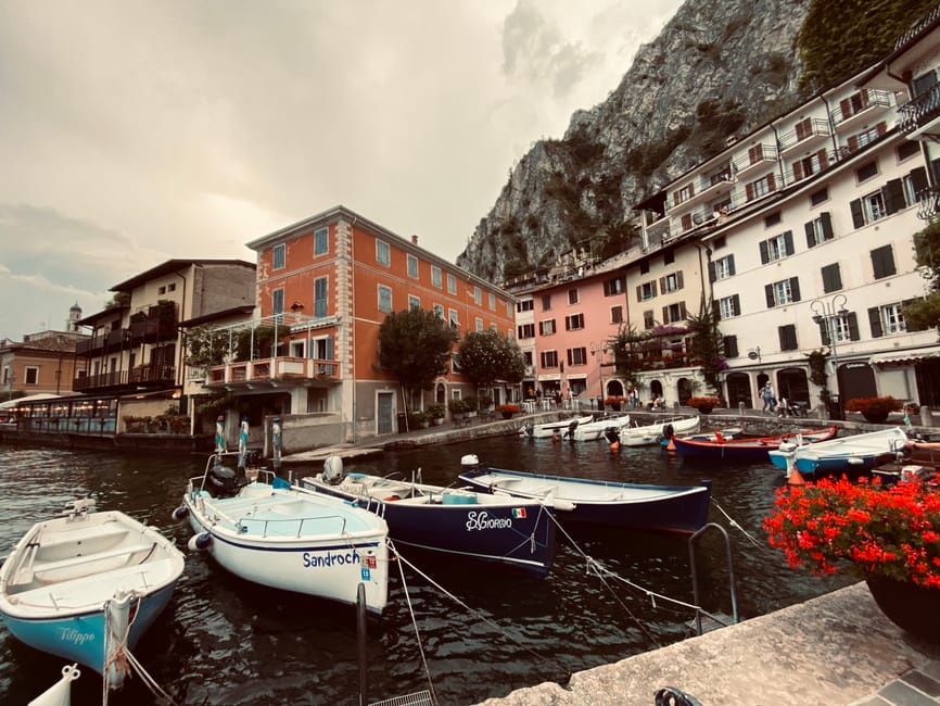 Mały port z kolorowymi łodziami i kamienicami nad Jeziorem Garda