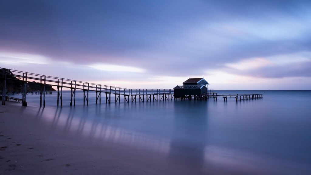 Wooden pier and boathouse extending over Lake Garda at twilight