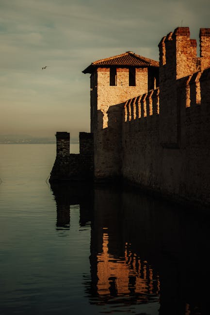 Scaliger castle walls reflecting in Lake Garda's water at dusk