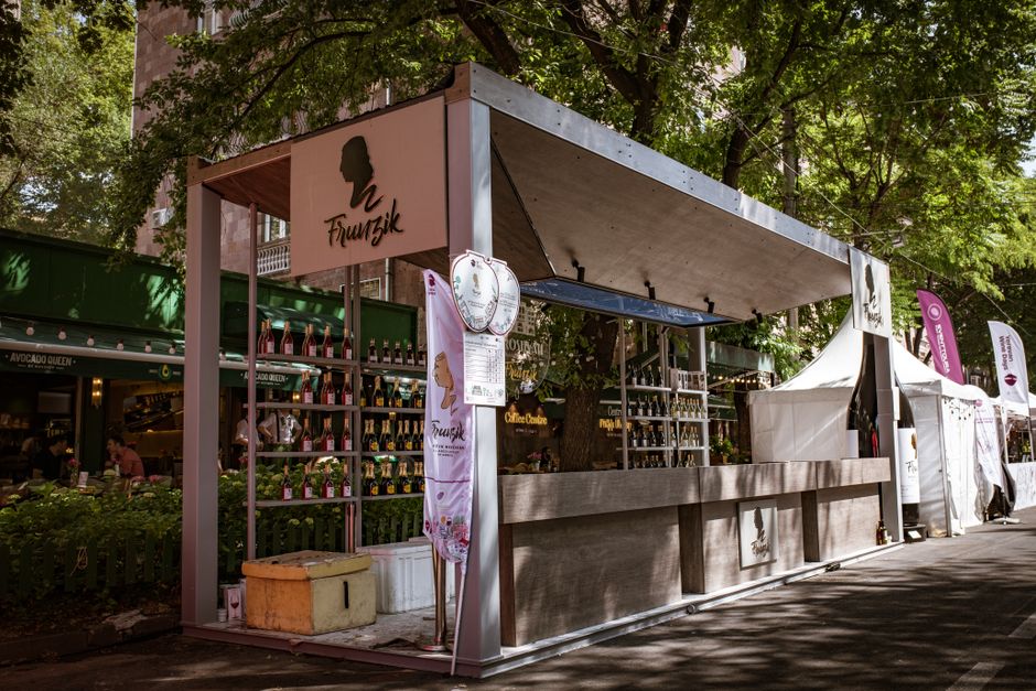 Stoisko z butelkami win na festiwalu nad Jeziorem Garda w cieniu drzew
