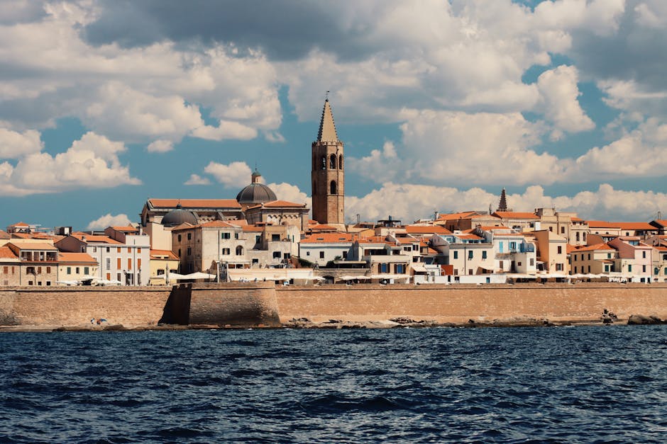 Panorama dal mare delle mura e campanile di una città costiera in Sardegna