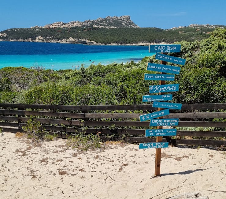 Cartelli con direzioni sulla spiaggia, mare turchese e macchia mediterranea in Sardegna