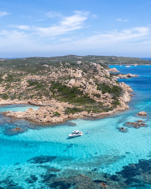 Türkisfarbenes Wasser mit Boot vor felsiger Küste von Sardinien
