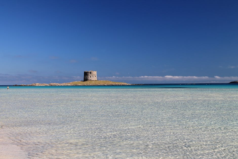 Acqua trasparente e torre aragonese su isolotto a La Pelosa, Sardegna