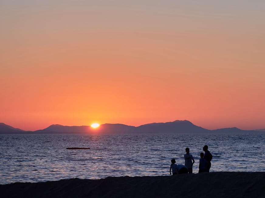 Tramonto arancione sul mare con silhouette di famiglia in spiaggia, Sardegna