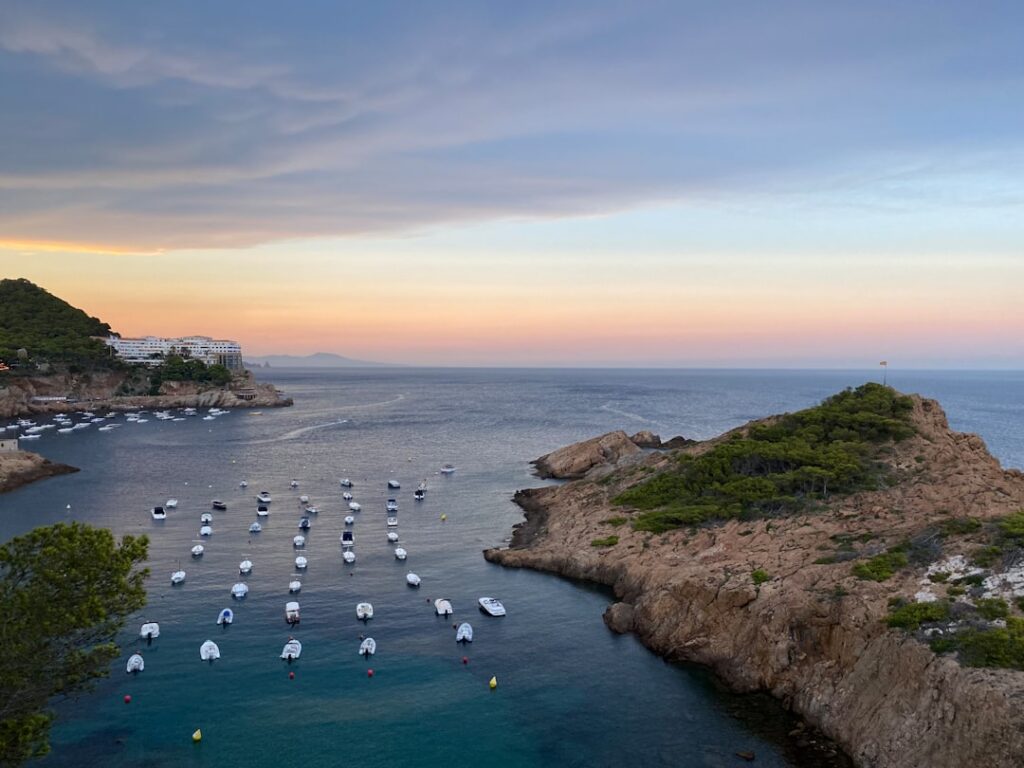 Barche ancorate in baia al tramonto lungo la Costa Smeralda, Sardegna
