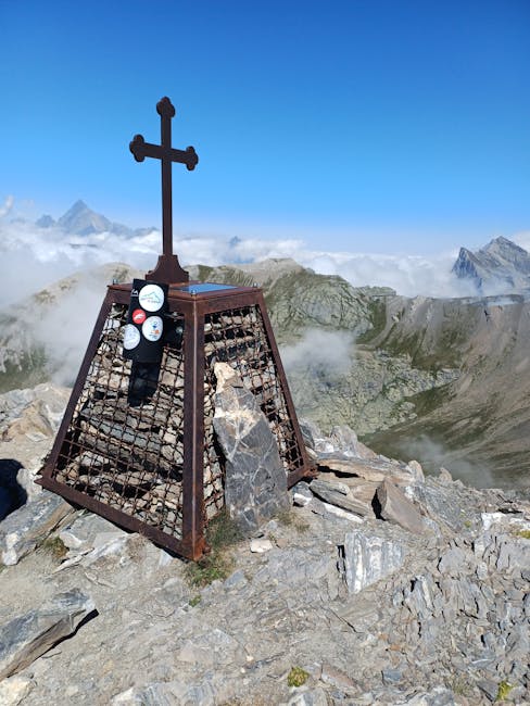 Croce metallica su cima rocciosa con vista sulle nuvole del Gennargentu