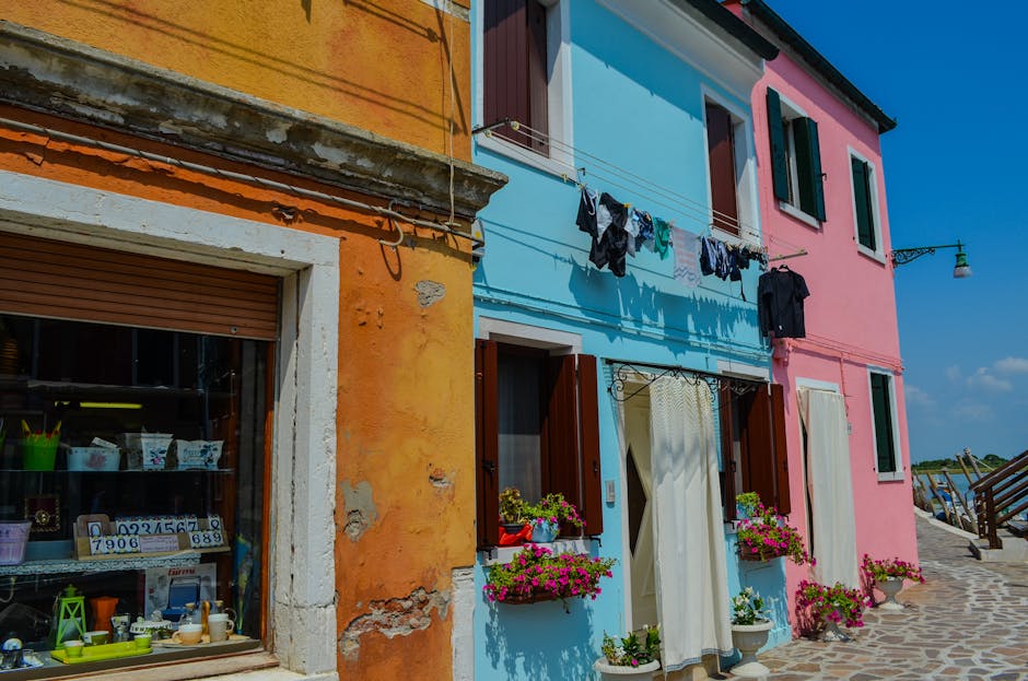 Bunte Fassaden mit Blumenkästen und Wäscheleine an sardischer Promenade
