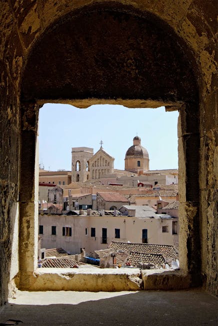 Vue sur cathédrale et toits de la ville depuis une fenêtre à Sardaigne