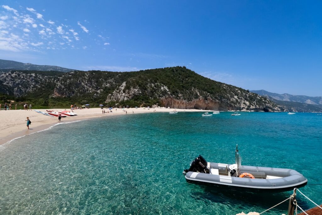 Bateau pneumatique ancré près d'une plage aux eaux turquoise en Sardaigne