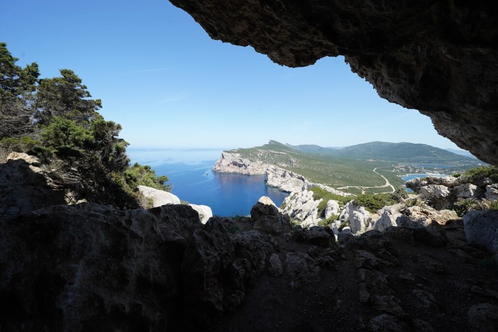 Vue depuis une grotte sur falaises et mer bleu profond en Sardaigne