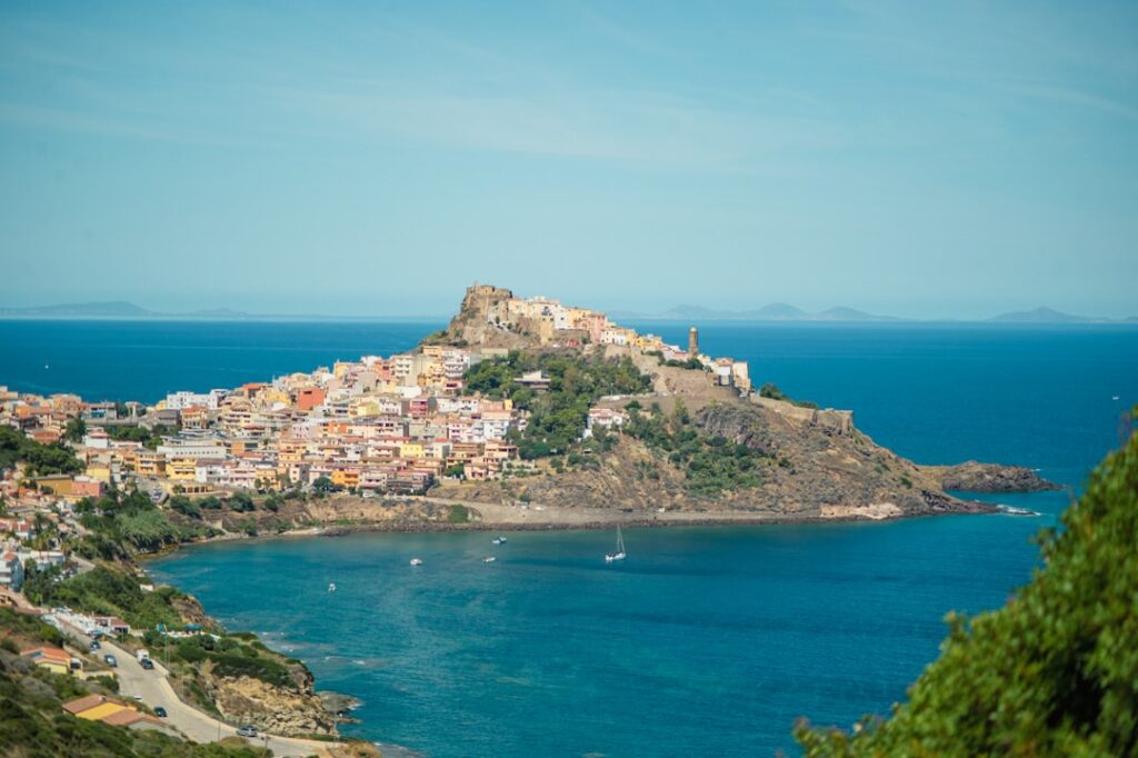 Veduta diurna di Castelsardo sul mare con barche nella baia
