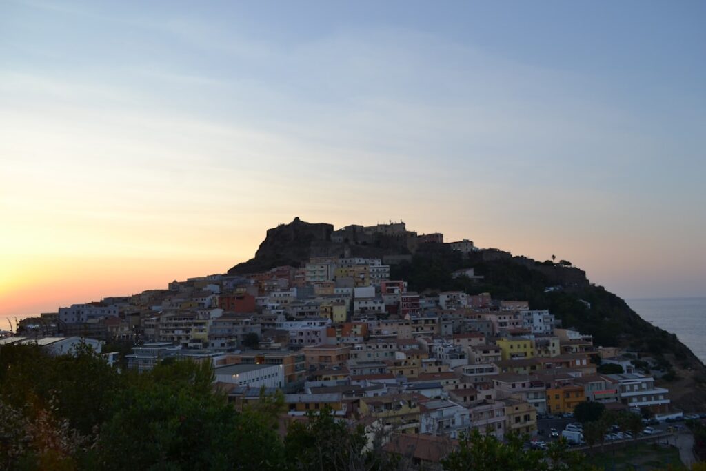 Castelsardo al tramonto con case colorate sul promontorio in Sardegna