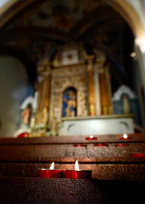 Candele votive accese davanti ad altare dorato sfocato