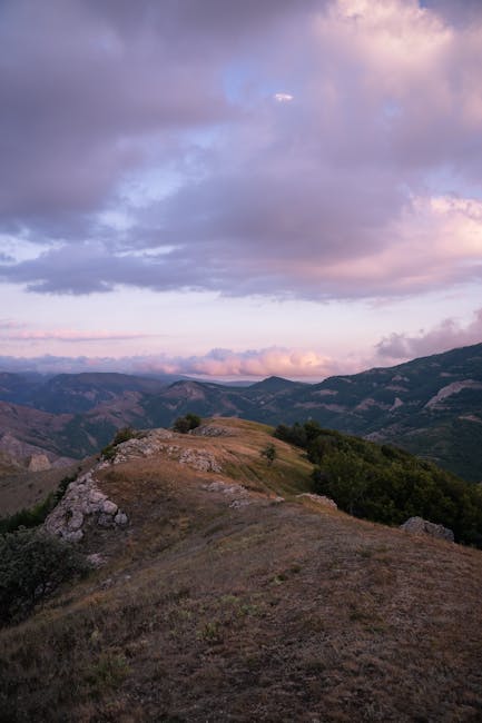 Felsgrat und sanfte Hügel unter rosa Wolken über Sardinien