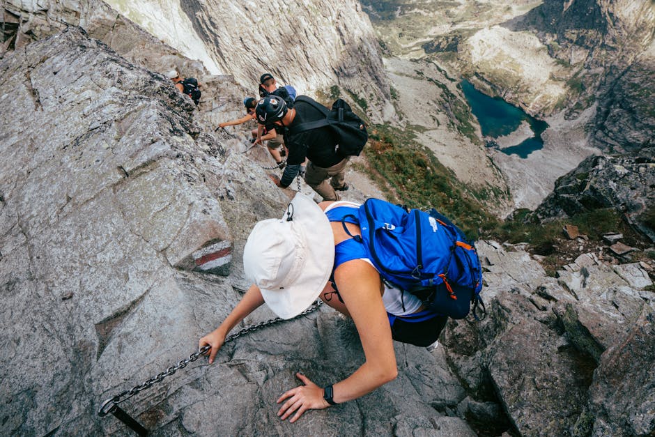 Wanderer klettern gesichert an Felskante über Bergsee in Sardinien