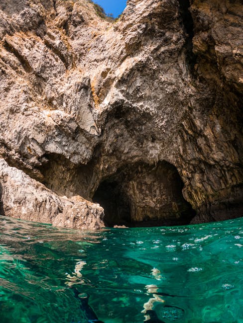 Entrata di una grotta marina con acqua turchese limpida in Sardegna